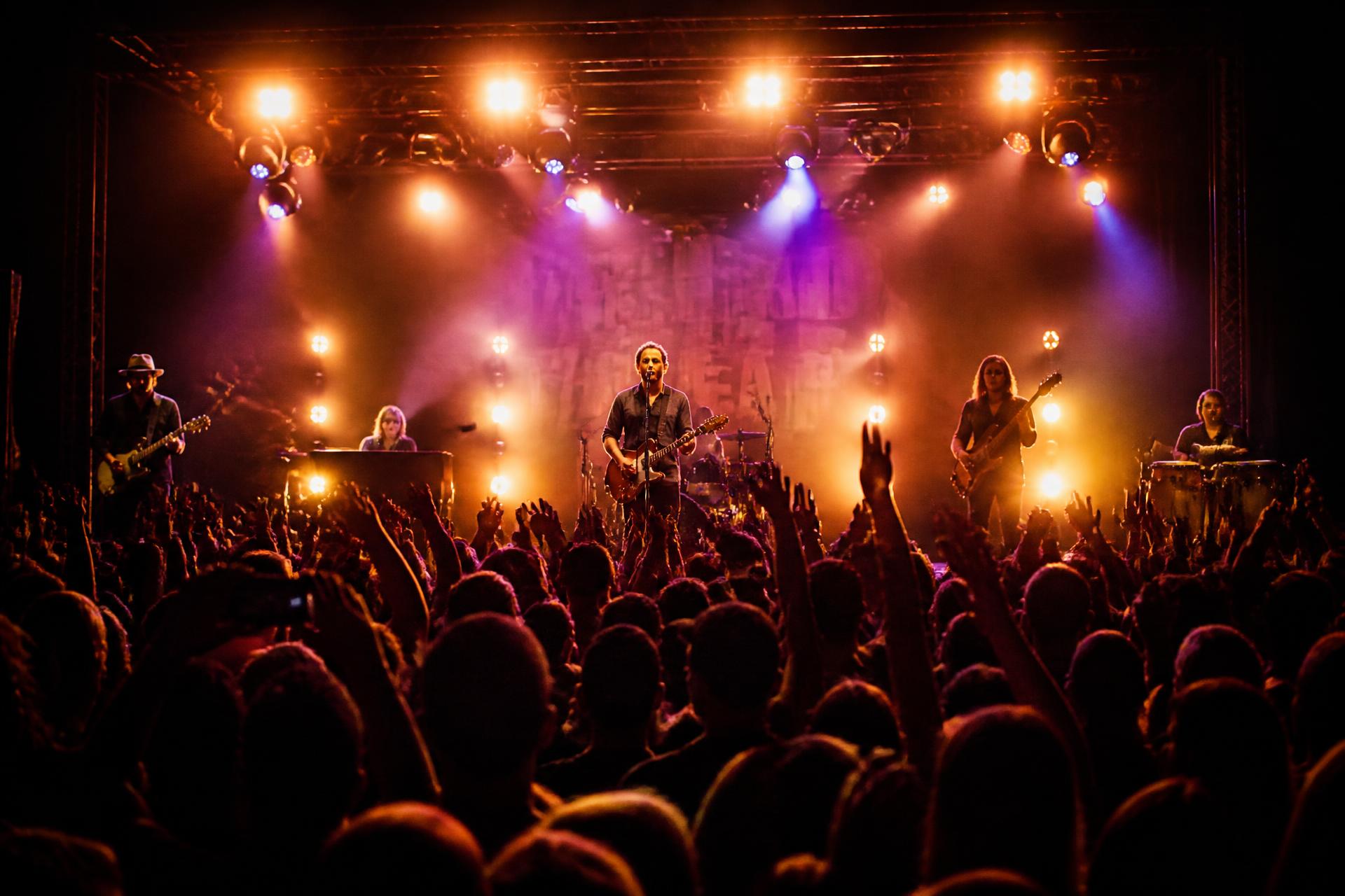 Live band on stage under warm concert lighting